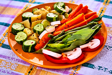 Image showing Ladle of steamed freshly harvested young vegetables including crinkle cut sliced carrots, peas and potato batons