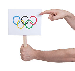 Image showing Hand holding small card - Flag of the Olympic games