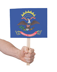 Image showing Hand holding small card - Flag of North Dakota