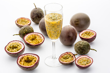 Image showing Passion Fruit Flesh In A Flute Amidst Cut Fruits