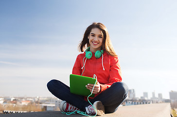 Image showing happy young woman with tablet pc and headphones