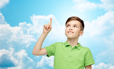 Image showing happy boy in green polo t-shirt pointing finger up