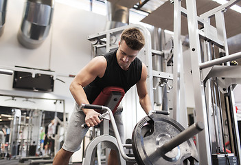 Image showing young man exercising on t-bar row machine in gym