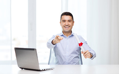 Image showing man with diploma and laptop pointing finger