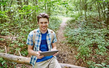 Image showing happy man with backpack and tablet pc in woods