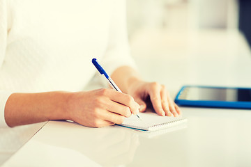 Image showing close up of hands with pen writing to notepad