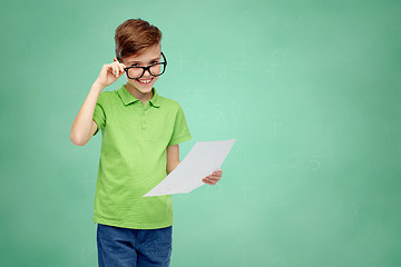 Image showing happy boy in eyeglasses holding school test result