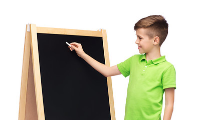 Image showing happy boy with chalk and blank school blackboard