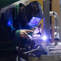 Image showing Industrial worker welding in metal factory.