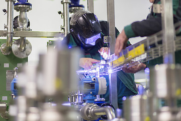 Image showing Industrial worker welding in metal factory.