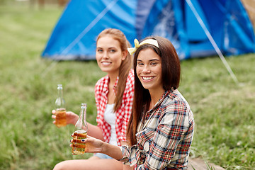 Image showing happy young women with tent and drinks at campsite