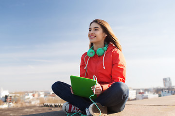 Image showing happy young woman with tablet pc and headphones