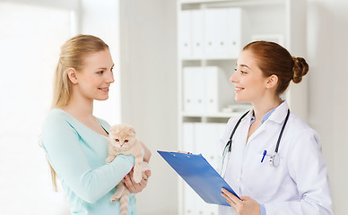 Image showing happy woman with cat and doctor at vet clinic