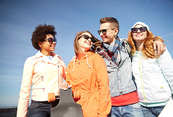 Image showing happy teenage friends in shades talking on street