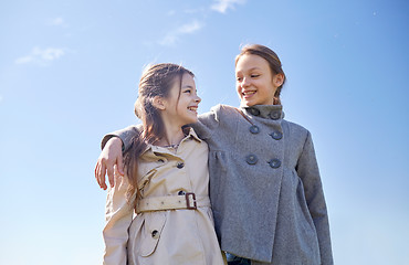 Image showing happy little girls hugging and talking outdoors