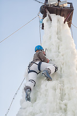 Image showing Girl climbs upward on ice climbing competition