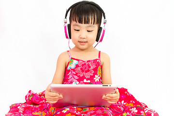 Image showing Chinese little girl on headphones holding tablet