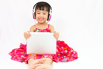 Image showing Chinese little girl on headphones holding tablet