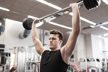 Image showing young man flexing muscles with barbell in gym