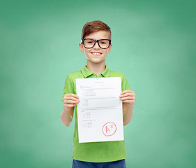 Image showing happy boy in eyeglasses holding school test result