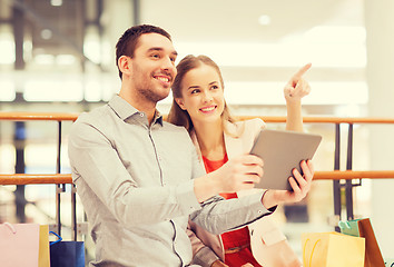 Image showing couple with tablet pc and shopping bags in mall