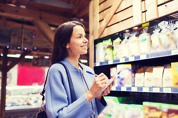 Image showing happy woman with notepad in market