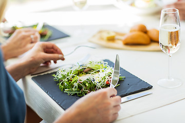 Image showing close up of woman eating salad at restaurant