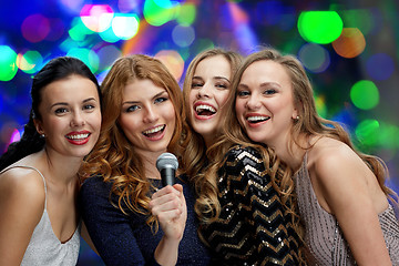 Image showing happy young women with microphone singing karaoke