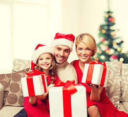 Image showing smiling family giving many gift boxes