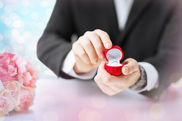 Image showing close up of man with gift box and engagement ring