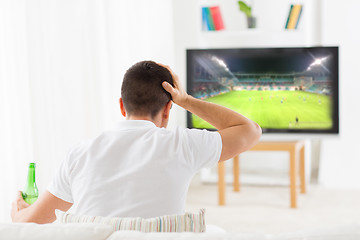 Image showing man watching football and drinking beer at home
