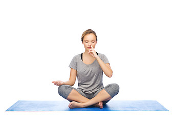 Image showing woman making yoga meditation in lotus pose on mat