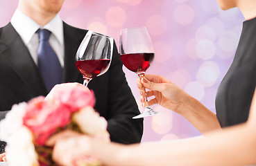 Image showing happy engaged with flowers clinking wine glasses