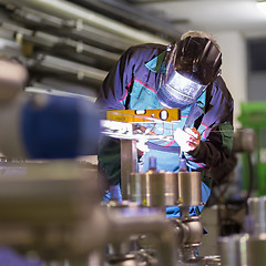 Image showing Industrial worker welding in metal factory.