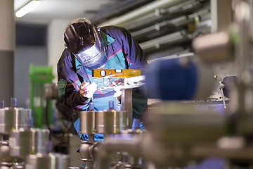 Image showing Industrial worker welding in metal factory.