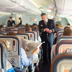 Image showing Steward and passengers on commercial airplane.