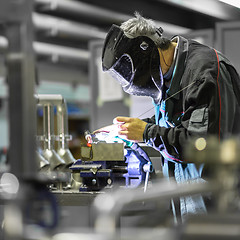 Image showing Industrial worker welding in metal factory.