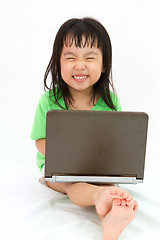 Image showing Chinese little girl sitting on floor with laptop