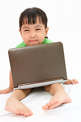 Image showing Chinese little girl sitting on floor with laptop