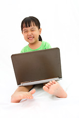 Image showing Chinese little girl sitting on floor with laptop