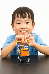 Image showing Chinese little girl pushing a toy shopping cart