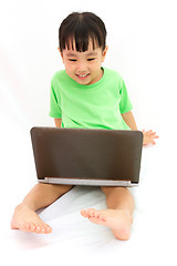 Image showing Chinese little girl sitting on floor with laptop