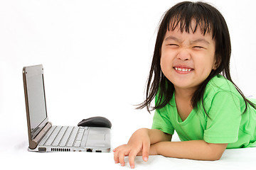 Image showing Chinese little girl lying down with laptop