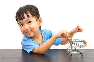 Image showing Chinese little girl pushing a toy shopping cart