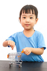 Image showing Chinese little girl pushing a toy shopping cart