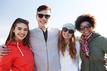 Image showing happy teenage friends in shades hugging outdoors