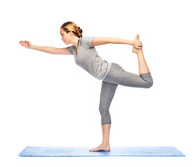 Image showing woman making yoga in lord of the dance pose on mat