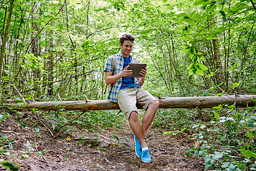 Image showing happy man with backpack and tablet pc in woods