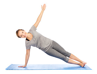 Image showing woman making yoga in side plank pose on mat