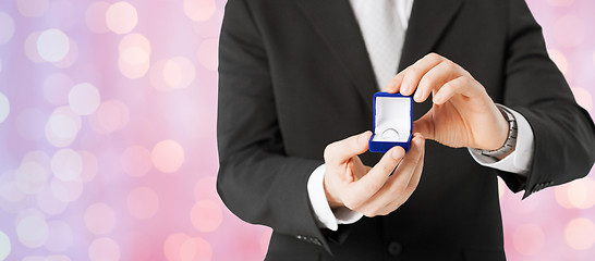 Image showing close up of man with gift box and engagement ring